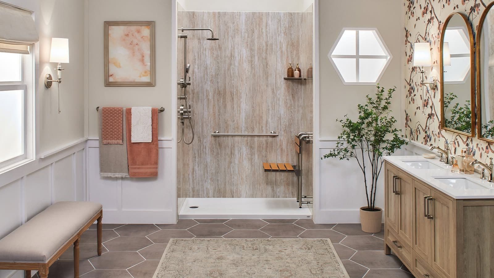 Modern spa-like bathroom with walk-in shower, double vanity, hexagonal mirror, wooden bench, and climbing ivy wallpaper accent wall